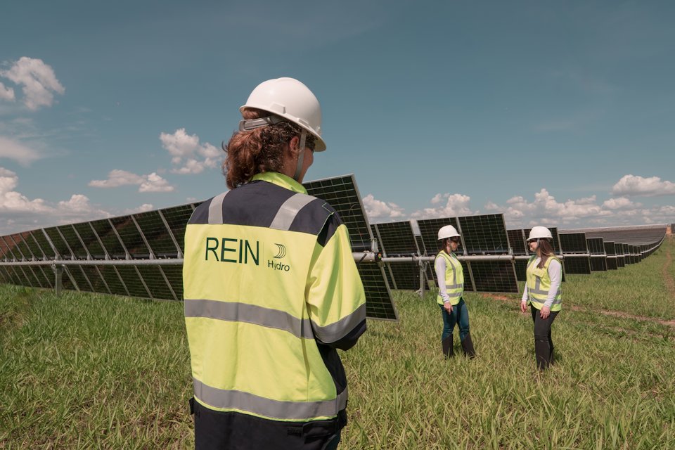 a group of people wearing hardhats and standing in a field