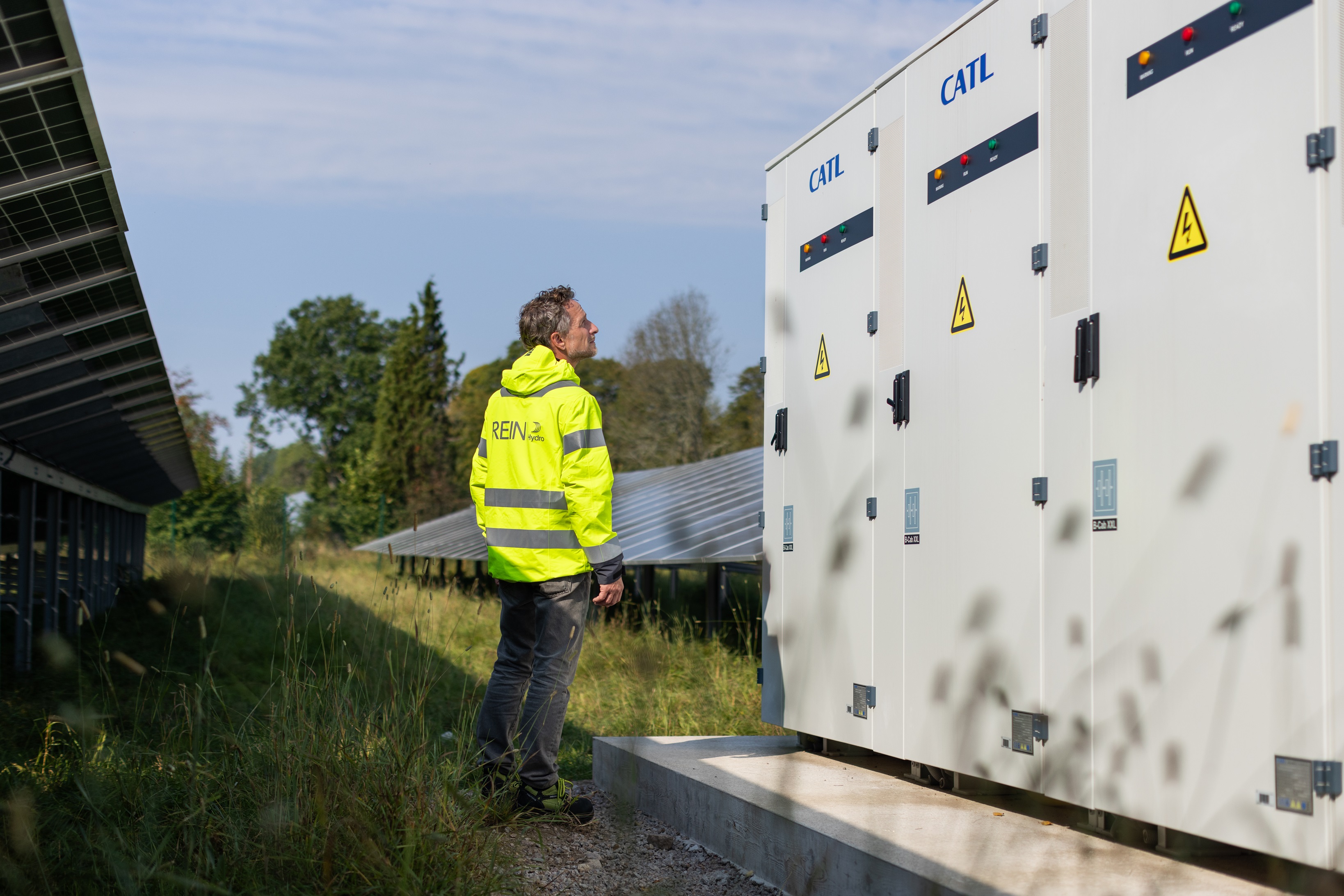 a man in a yellow jacket standing next to a white box