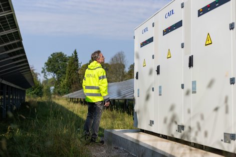 a man in a yellow jacket standing next to a white box