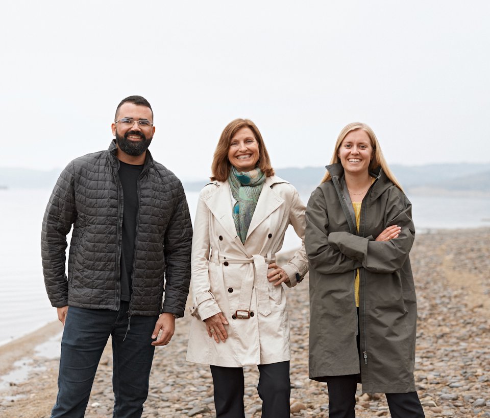 a group of people posing for a photo on a beach